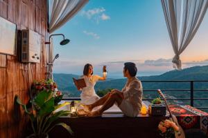 Ban Thung Phan Haม่อนสาเคียงดาว的一男一女坐在阳台上欣赏美景