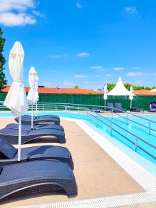 - une rangée de chaises et de parasols à côté de la piscine dans l'établissement Natura Resorts, à Casalarreina