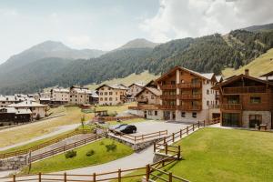 a village in the mountains with a car parked at Bonvivar -- Mountain Guesthouse in Livigno