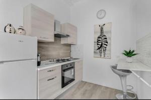 a white kitchen with a refrigerator and a sink at Galeno in Milan