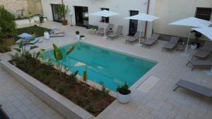 an overhead view of a swimming pool with chairs and umbrellas at B&B Case Marcapane in Sommatino