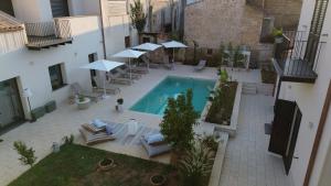 an overhead view of a swimming pool with chairs and umbrellas at B&B Case Marcapane in Sommatino