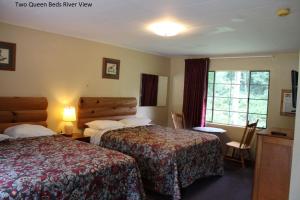 a hotel room with two queen beds and a window at Two Rivers Lodge in Bryson City