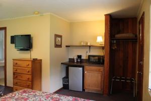 a room with a bed and a kitchen with a television at Two Rivers Lodge in Bryson City +20 photos