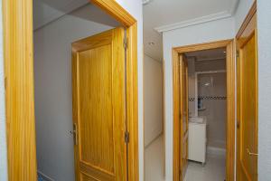 einen Flur mit Holztür und ein Badezimmer in der Unterkunft 068 Nice corner La Mata - Alicante Holiday in La Mata