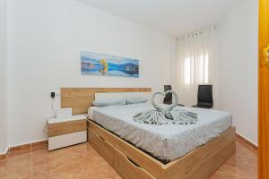ein Schlafzimmer mit einem Bett mit zwei Schwänen darauf in der Unterkunft 155 Wonderfull Luxury apartment Alicante-Holiday in Torrevieja