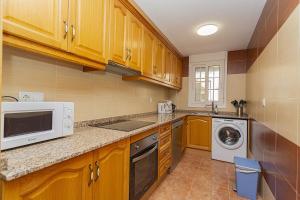 eine Küche mit Holzschränken, einer Waschmaschine und einem Trockner in der Unterkunft 155 Wonderfull Luxury apartment Alicante-Holiday in Torrevieja