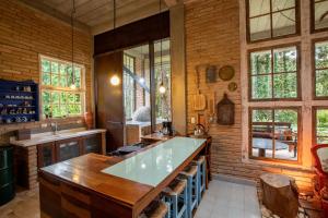 a kitchen with a large counter and some windows at Design Home by The Lodges in Campos do Jordão +44 photos