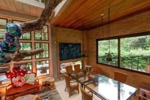 a living room with a table and some windows at Design Home by The Lodges in Campos do Jordão