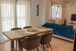ein Esstisch mit Stühlen und ein blaues Sofa in der Unterkunft Cleo in Spáta