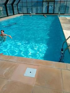 a man swimming in a large swimming pool at La Campana 107 in Bielle