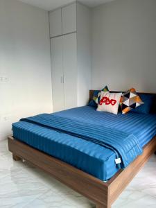 a bedroom with a bed with blue sheets and pillows at HT Home D'el Dorado 1 in Hanoi +15 photos