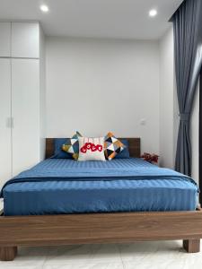a bedroom with a large bed with blue sheets at HT Home D'el Dorado 1 in Hanoi