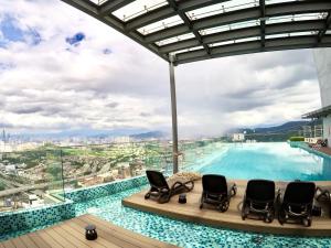 a pool with chairs and a view of a city at EkoCheras Suites, Kuala Lumpur by Idealhomes in Kuala Lumpur