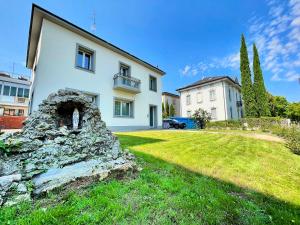 a white house with a stone wall in the yard at Villa Manzoni in Meda