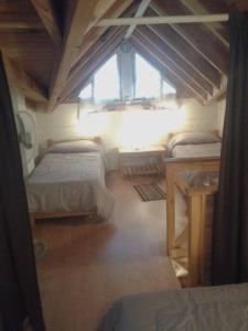 a small room with two beds and a window at Cabañas Orillas del Chimehuín -Cabaña Chica 4 pax- in Junín de los Andes