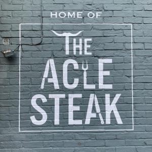 a sign that says home of the acid steal on a brick wall at The Kings Head Inn, Home of The Acle Steak in Acle
