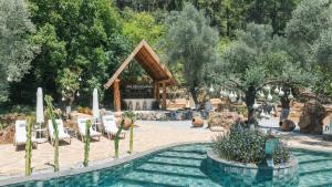 a pavilion with chairs and a pool in a garden at Pure Life Göcek in Gökçeovacık