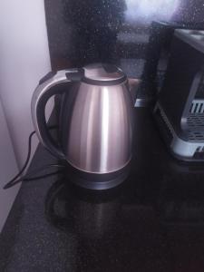 a tea kettle sitting on a counter next to a microwave at Λευκό σπίτι in Ksamil
