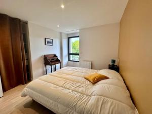 a bedroom with a large bed and a piano at Entre St Malo et Rennes, grande maison 12 couchages Chez Yvonne in Irodouër +38 photos