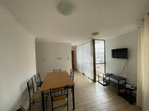 a dining room with a table and chairs and a television at Edificio INMOBILIA - Av Argetina 2 dormitorios in Antofagasta