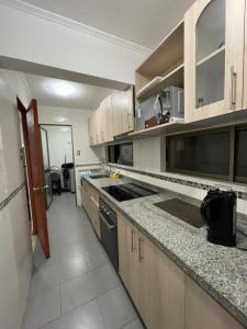 a kitchen with wooden cabinets and a counter top at Edificio INMOBILIA - Av Argetina 2 dormitorios in Antofagasta