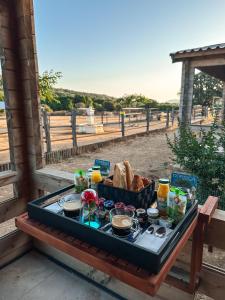 un plateau de nourriture sur une table sur un banc dans l'établissement Les Chalets de Tesa, à Occhiatana