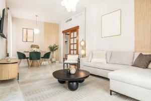a living room with a couch and a table at Stay and support - charitable apartments by REMS in Málaga