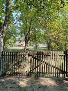 a wooden fence in a park with a tree at Domacinstvo Pecina Petnica in Petnica
