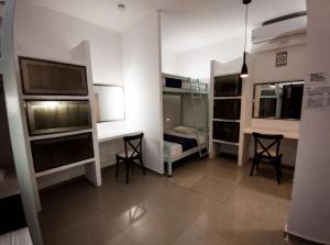 a room with two beds and a desk and two chairs at Hostal del Mar in Playa del Carmen