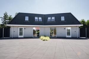 una casa de ladrillo blanco con techo negro en Vakantiehuis Noordwijk, en Noordwijk