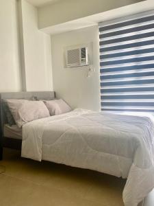 a bedroom with a bed and a window with a air conditioner at B & M Condo near NAIA Airport and SM Mall in Manila +27 photos