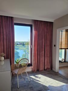 a room with a chair and a large window at Apartamenty K17 Stare Miasto in Malbork