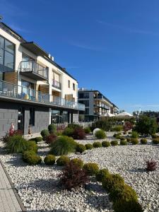 a garden in front of a building with plants at MB Apartments z Basenem i Ogrodem in Sarbinowo