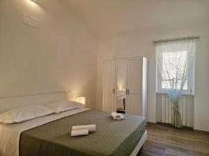 a bedroom with a bed with two towels on it at Casa Adelina by TraMonti Apartments in Poggio Picenze