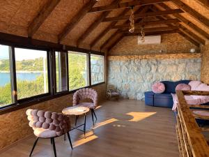 a living room with a couch and chairs and windows at Lake house Zoya in Nikšić +16 photos