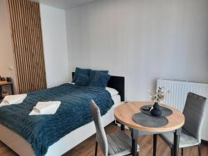 a small room with a bed and a table with a table at LOCUS SKY TOWER Katowice in Katowice