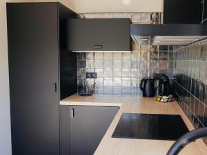 Una cocina con gabinetes negros y encimera. en Vakantiehuis Noordwijk, en Noordwijk