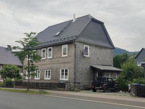 uma casa com um jipe estacionado em frente em Ferienwohnung Finkeldei em Winterberg