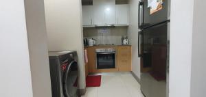 a small kitchen with a refrigerator and a dishwasher at 2BR at the FORT BGC near Malls, Restaurants & Shops in Manila