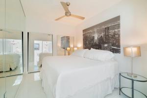 a white bedroom with a bed and a ceiling fan at The Palms Suite - Casa Costa 309S 1 Bedroom, Pools, Jacuzzi, Beach, Shops & Dog Friendly in Boynton Beach +37 photos