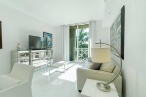 a living room with white furniture and a television at The Palms Suite - Casa Costa 309S 1 Bedroom, Pools, Jacuzzi, Beach, Shops & Dog Friendly in Boynton Beach
