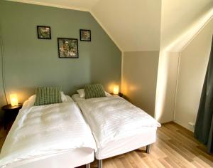 2 camas en un dormitorio con 2 luces en la pared en Paradise Cave Hostel & Guesthouse, en Hvolsvöllur