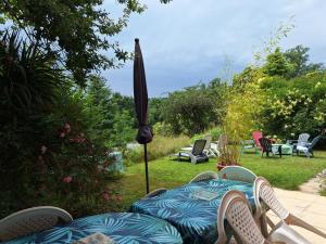 a patio with an umbrella and chairs and a table at Maison tout confort Figeac in Figeac