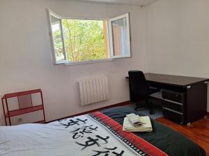 a bedroom with a desk and a bed and a deskictericter at Maison tout confort Figeac in Figeac