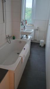 a white bathroom with a tub and a sink at Oase Coswig Ferienwohnung in Coswig