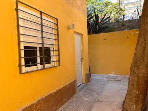 a yellow building with a window and a door at Apartamentos Yiya in Málaga