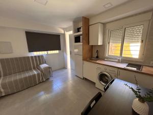 a kitchen and living room with a couch and a table at Apartamentos Yiya in Málaga +5 photos