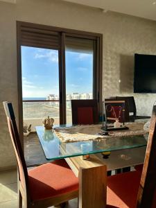 a dining room with a glass table with a view of the ocean at Appartement moderne à Puerto Banus in Mansouria +2 photos