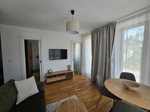 un soggiorno con un divano e un tavolo di Apartman Crni Vrh - DivčiNova a Divčibare